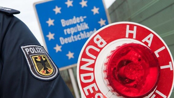 Auf einer Winkerkelle der Polizei steht "Halt Bundespolizei". Dahinter ein blaues Schild "Bundesrepublik Deutschland". © Bundespolizeiinspektion Bad Bentheim 