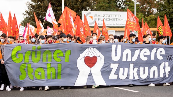 Der Schriftzug "Grüner Stahl - Unsere Zukunft" ist auf einem Banner während einer Kundgebung der IG Metall vor dem Werk der Salzgitter AG zu lesen.  Foto: Moritz Frankenberg