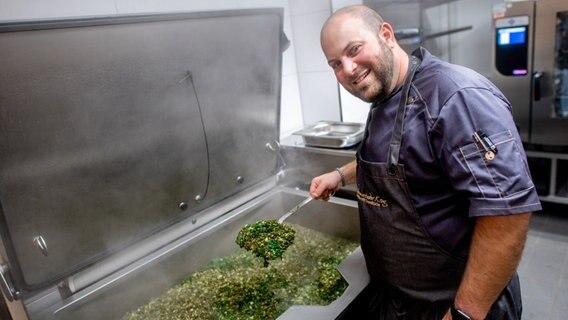 Koch Nico Winkelmann bereitet in der Küche vom "Bümmersteder Krug" Grünkohl zu. © dpa Foto: Hauke-Christian Dittrich/dpa