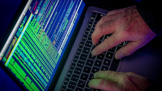 Symbolbild zu Computerhackern. Hände an einem Laptop. Auf dem Bildschirm ist grüne Schrift zu sehen. © picture alliance / Jochen Tack | Jochen Tack Foto: Jochen Tack