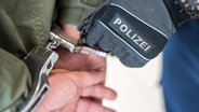 Ein Polizist legt einem Menschen Handschellen an. © Bundespolizei 