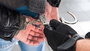 Ein Mann wird mithilfe von Handschellen festgenommen. (Symbolbild) © Bundespolizei 