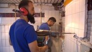 Zwei Geflüchtete arbeiten in einer Baustelle. © NDR 