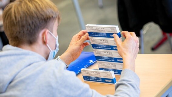 Ein Schüler stapelt Schnelltestverpackungen übereinander. © dpa-Bildfunk Foto: Moritz Frankenberg