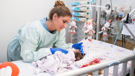 Eine Kinderkrankenschwester versorgt ein Neugeborenes auf der Kinderintensivstation. © dpa-Bildfunk Foto: Ole Spata