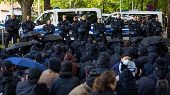 Polizistinnen und Polizisten stehen vor einer Sitzblockade von Demonstrierenden gegen den AfD-Landesparteitag in Hannover Polizistinnen und Polizisten stehen vor einer Sitzblockade von Demonstrierenden gegen den AfD-Landesparteitag in Hannover © dpa Bildfunk Foto: Moritz Frankenberg