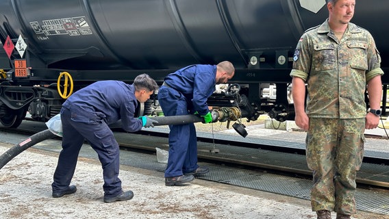 Mitarbeiter der Bundeswehr bringen einen Schlauch an einem mobilen Kerosintank an. © NDR Foto: Bertil Starke