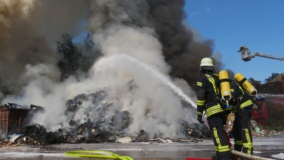Feuerwehrleute löschen einen brennenden Müllhaufen auf dem Gelände eines Entsorgungsbetriebs in Altencelle. © Feuerwehr Celle 