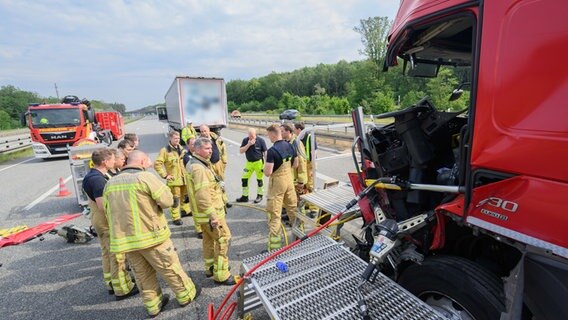 Einsatzkräfte der Feuerwehr Hannover stehen neben einem verunfallten Lkw auf der Autobahn A7 im Autobahnkreuz Hannover-Ost. © dpa-Bildfunk Foto: Julian Stratenschulte
