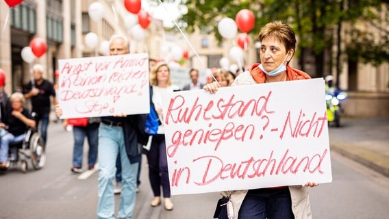 Die Schriftzüge «Angst vor Armut in einem reichen Deutschland! Stop!» und «Ruhestand genießen? - Nicht in Deutschland» sind auf Plakaten von Demonstranten bei einer vom Sozialverband Deutschland initiierten Demonstration gegen Armut zu lesen. © dpa-Bildfunk Foto: Moritz Frankenberg