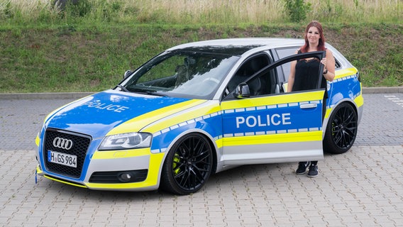 Autotunerin Svenja Geertz steht neben ihrem Auto, das wie ein Polizeiauto aussieht. Auf dem Auto steht "Police". © picture alliance/dpa | Julian Stratenschulte Foto: Julian Stratenschulte