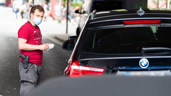 Ein Polizist in zivilkleidung kontrolliert ein Fahrzeug. © dpa Foto: Philipp Schulze