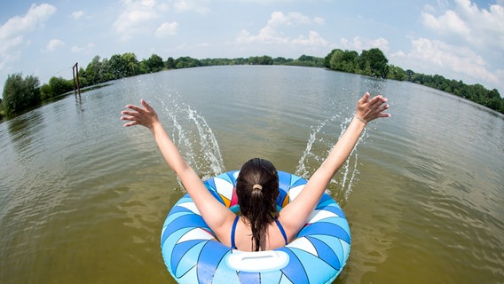 Uetze: Ein junge Frau badet mit einem Schwimmreifen im Irenensee © picture alliance Foto: Hauke-Christian Dittrich