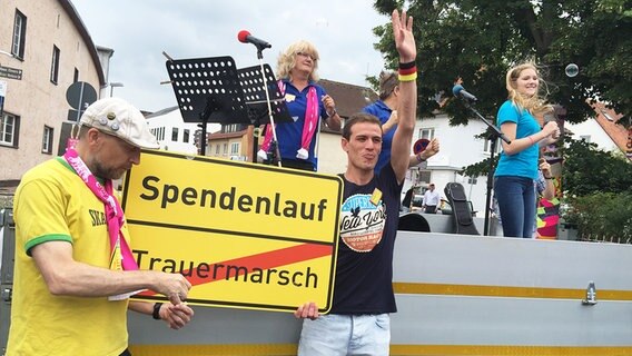 Menschen demonstrieren vor dem Winckler-Bad in Bad Nenndorf gegen Rassismus mit einer Feier. © NDR Foto: Stefan Schölermann
