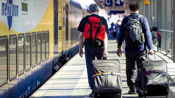 Reisende gehen einen Bahnsteig im Hauptbahnhof Hannover entlang. © picture alliance/dpa Foto: Moritz Frankenberg