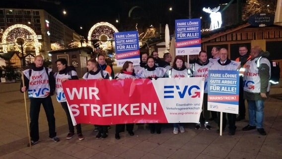 Streikende der Eisenbahn- und Verkehrsgewerkschaft EVG posieren mit Schildern und einem Banner.  Foto: Helmut Eickhoff