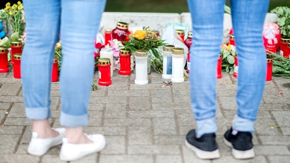 Niedersachsen, Barsinghausen: Zwei Frauen stehen vor Kerzen, Blumen und Stofftieren, die als Zeichen der Trauer am Fundort einer getöteten jungen Frau nahe einer Grundschule abgelegt wurden. © dpa-Bildfunk Foto: Hauke-Christian Dittrich