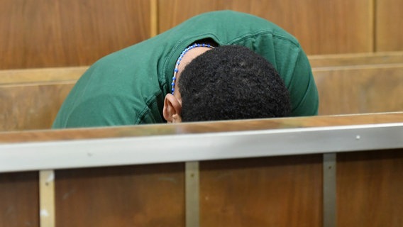 Ein Mann sitzt mit gesenktem Kopf auf einer Holzbank im Gericht.. © dpa-Bildfunk Foto: Holger Hollemann