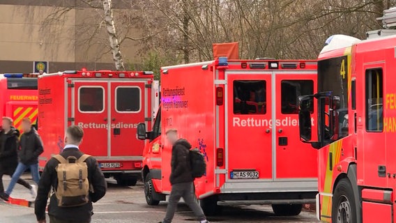 Mehrere Krankenwagen stehen vor einer Schule. © NDR 