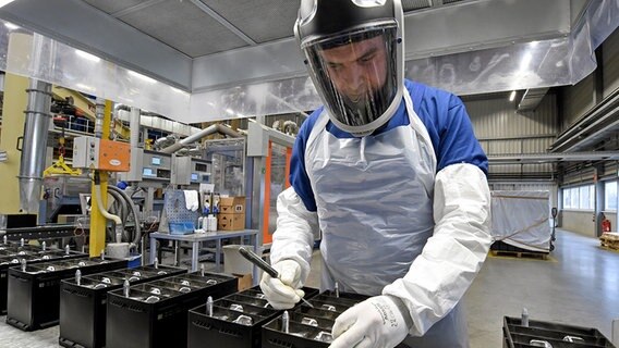 Ein Mitarbeiter arbeitet an der Endkontrolle für Batteriekästen. © dpa-Bildfunk Foto: Holger Hollemann