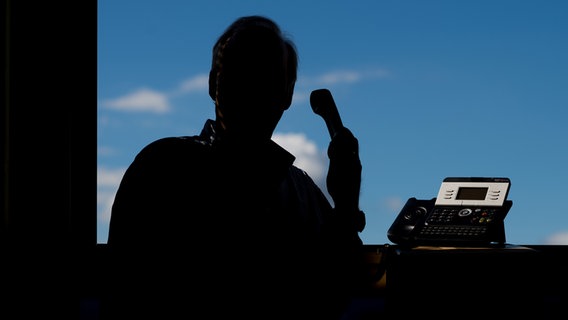 Ein Mann hält einen Telefonhörer in der Hand. © dpa-Bildfunk Foto: Julian Stratenschulte