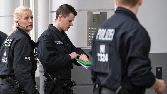 Polizisten stehen an einer Haustür. © dpa-bildfunk Foto: Peter Steffen