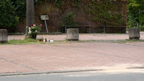 Blumen und Kerzen stehen hinter dem mit Sand bestreuten Tatort in der Innenstadt von Burgdorf bei Hannover. © dpa Foto: Mia Bucher