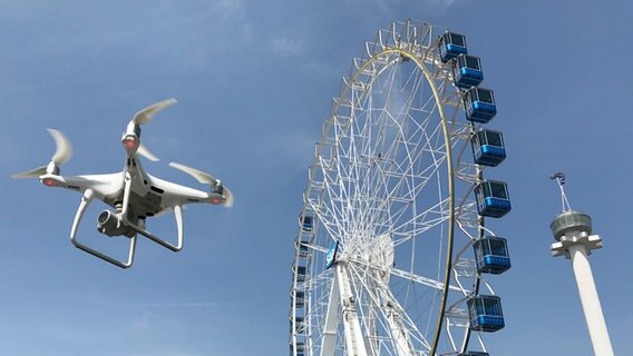 Ein Riesenrad des Softwareherstellers SAP wird auf dem Messegelände Hannover aufgebaut. Im Vordergrund fliegt eine Drohne. © dpa-Bildfunk Foto: Julian Stratenschulte