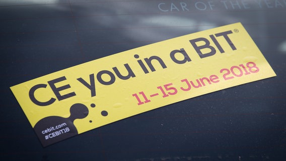 "Ce you in a BIT" steht auf einem Aufkleber auf einer Autoscheibe im Vorfeld der Messe. © dpa-Bildfunk Foto: Friso Gentsch