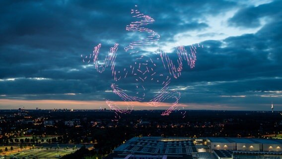 Bunte Linien und Punkte sind vor wolkenverhangenem Abendhimmel in Hannover zu sehen. © Messe Hannover Foto: Rainer Jensen
