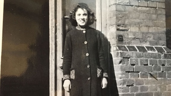 Die Schwarz-Weiß-Fotografie zeigt Ruth Gröne mit zwölf Jahren vor ihrem Wohnhaus, dem 'Judenhaus' in Hannover-Ahlem. © NDR 