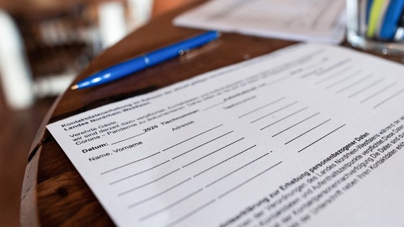 Ein Formular zur Erhebung der Kontaktdaten liegt in einem Café auf einem Tisch. © picture alliance/Hauke-Christian Dittrich/dpa Foto:  Fabian Strauch