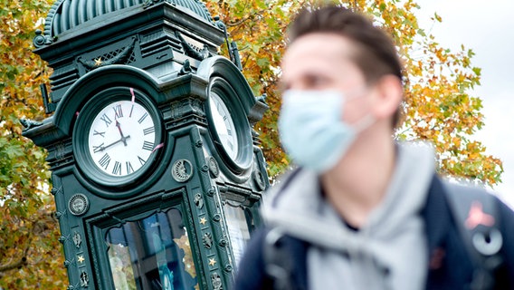 Ein Mann trägt am Kröpcke in Hannover eine Mund-Nasen-Bedeckung. © picture-alliance Foto: Hauke-Christian Dittrich