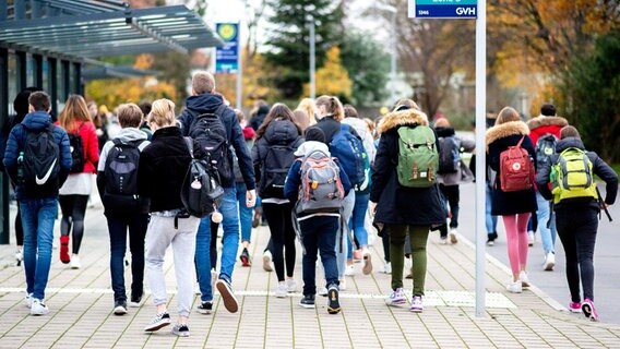 Schülerinnen und Schüler gehen von einer Bushaltestelle zu ihrer Schule. © dpa-Bildfunk Foto: Hauke-Christian Dittrich