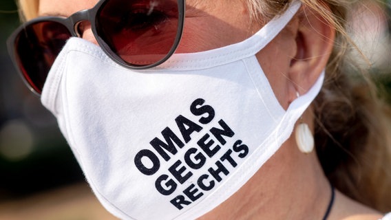Eine Frau mit einer Maske mit der Aufschrift: OMAS GEGEN RECHTS © picture alliance/dpa Foto: Hauke-Christian Dittrich