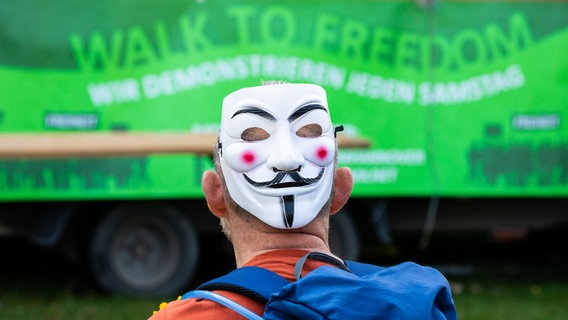Ein Demonstrant mit einer Anonymus-Maske auf dem Hinterkopf bei einer Demonstration gegen die Corona-Maßnahmen in der Innenstadt Hannovers. © dpa-Bildfunk Foto: Moritz Frankenberg