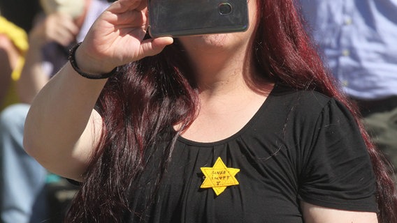Eine Gegnerin der Corona-Maßnahmen trägt bei einer Demonstration einen gelben Davidstern mit der Aufschrift "ungeimpft". © monitorex 