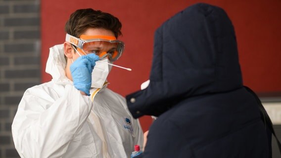 Ein Mitarbeiter einer Arztpraxis in der Region Hannover nimmt einen Abstrich von einer Patientin für einen PCR-Test. © dpa-Bildfunk Foto: Julian Stratenschulte