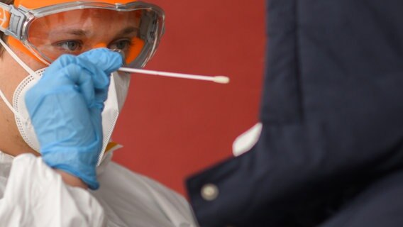 Ein Mitarbeiter einer Arztpraxis in der Region Hannover nimmt einen Abstrich von einer Patientin für einen PCR-Test. © dpa-Bildfunk Foto: Julian Stratenschulte