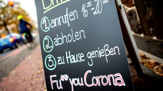 Eine Tafel mit der Aufschrift: "Drive-In und FU Corona" ist an einem Baum gelehnt. © dpa-Bildfunk Foto: Hauke-Christian Dittrich