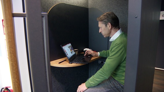 Ein Mann arbeitet an einem Laptop in einer Kabine im Co-Working-Space am Bahnhof Hannover. © NDR 