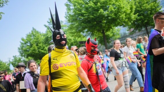 Ein Teilnehmer in Trikot von Bundesligist Borussia Dortmund geht beim Christopher Street Day (CSD) durch die Innenstadt. © dpa-Bildfunk Foto: Julian Stratenschulte