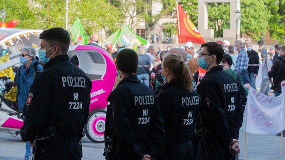 Mehrere Demonstranten gehen in richtung Opernplatz in Hannover. Im Vordergrund Beamte der Polizei mit Mundschutz. © dpa-Bildfunk Foto: Julian Stratenschulte