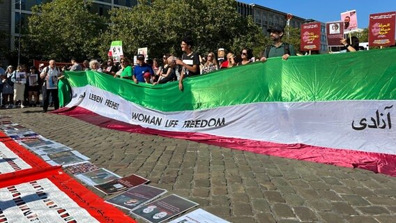 Auf dem Bild sind demonstrierende Menschen auf dem Opernplatz in Hannover zu sehen. Ein Banner zeigt den Schriftzug "Women - Life - Freedom" der iranischen Demokratiebewegung. © NDR/Bertil Starke Foto: Bertil Starke