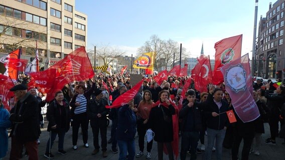 Mehrere hundert Menschen haben sich für eine Demonstration versammelt und halten zum Teil türkische Flaggen in die Luft. © NDR Foto: Bernd Reiser