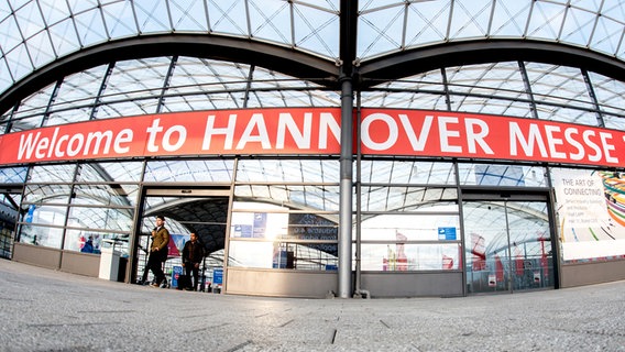 Über dem Eingang zu einer Halle auf dem Gelände der Deutschen Messe AG in Laatzen ist ein großer Schriftzug mit der Aufschrift "Welcome to Hannover Messe" zu sehen. Über dem Eingang zu einer Halle auf dem Gelände der Deutschen Messe AG in Laatzen ist ein großer Schriftzug mit der Aufschrift "Welcome to Hannover Messe" zu sehen. © dpa - Bildfunk Foto: Hauke-Christian Dittrich