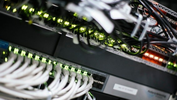 An einem Switch in einem Serverraum sind zahlreiche Verschaltungen, Label und LEDs zu sehen. © NDR Foto: Julius Matuschik