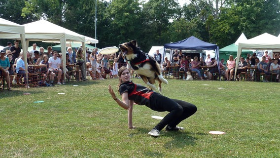 Eine Hundehalterin führt ein Kunststück mit ihrem Hund vor © Stadt Events GmbH 