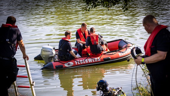 Einsatzkräfte sind in einem Boot im Wasser vom Dreiecksteich unterwegs. In dem Baggersee ist ein Mann ertrunken. © dpa-Bildfunk/Moritz Frankenberg/dpa Foto: Moritz Frankenberg