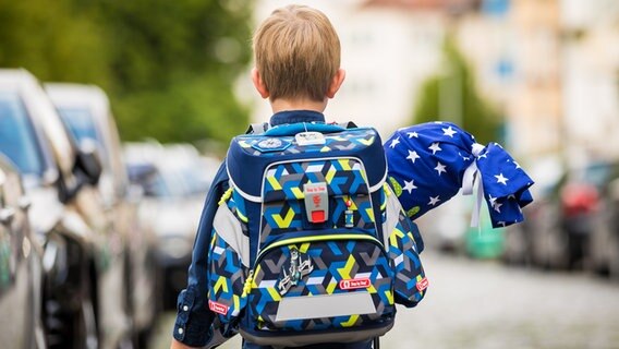 Ein Erstklässler steht mit Ranzen und Schultüte am Tag seiner Einschulung. © picture alliance/dpa Foto: Moritz Frankenberg